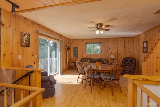4427 Tip Up Trl, Eagle River, WI 54521 - dining room featuring light wood-type flooring, a ceiling fan, wooden walls, and electric panel