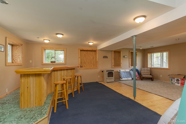 4427 Tip Up Trl, Eagle River, WI 54521 - playroom featuring a dry bar, wood finished floors, plenty of natural light, and a wood stove