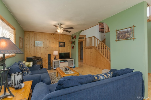 4427 Tip Up Trl, Eagle River, WI 54521 - living area with stairs, arched walkways, wood walls, a wood stove, and wood finished floors