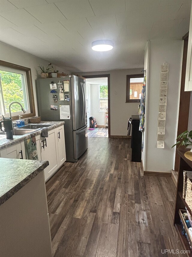 312 N Mckenzie Ave, Negaunee, MI 49866 - kitchen featuring freestanding refrigerator, a sink, dark wood finished floors, and white cabinets