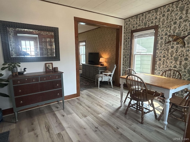 312 N Mckenzie Ave, Negaunee, MI 49866 - dining space featuring wallpapered walls, healthy amount of natural light, wood finished floors, baseboards, and crown molding