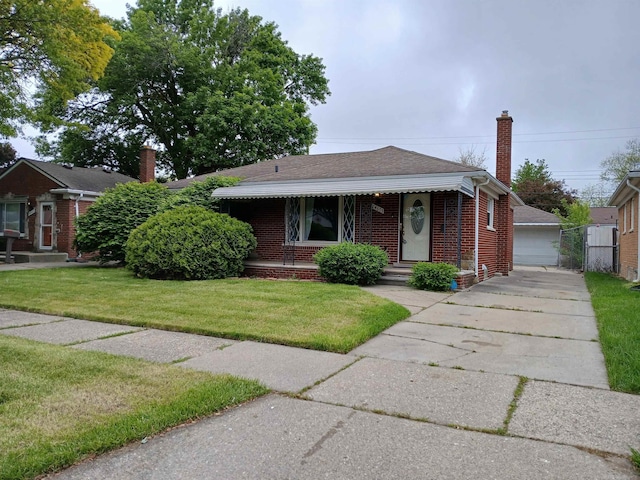 24675 Ridgecroft Ave, Eastpointe, MI 48021 - bungalow featuring brick siding, a front yard, a chimney, a detached garage, and a shingled roof