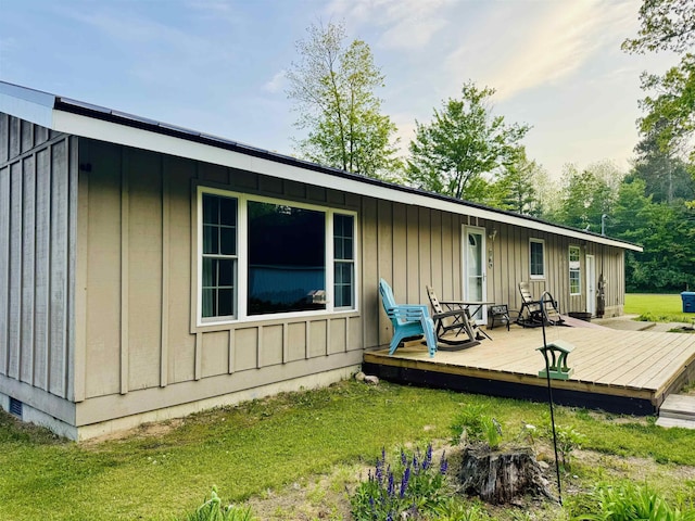 6223 E Townline Lake Rd, Harrison, MI 48625 - rear view of property with a deck, board and batten siding, and a yard