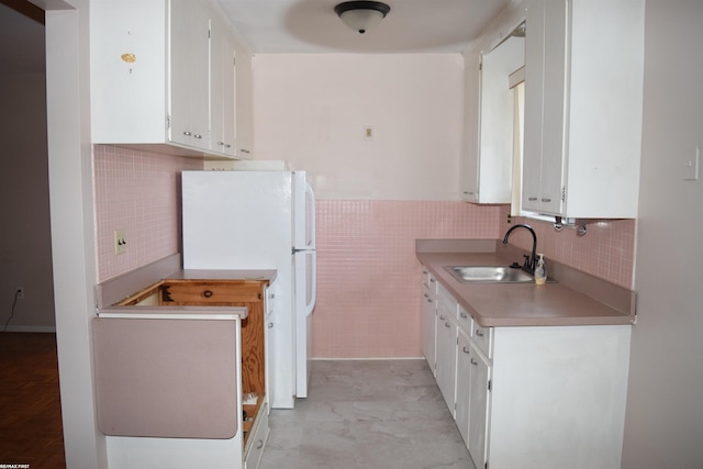 22800 Beaconsfield Ave, Eastpointe, MI 48021 - kitchen featuring a sink, freestanding refrigerator, white cabinets, tile walls, and light countertops