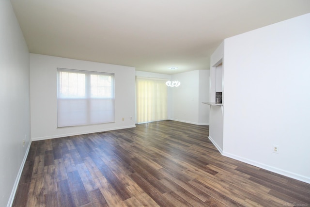 249 Brookwood Dr Unit 4, South Lyon, MI 48178 - spare room featuring dark wood-style floors, baseboards, and a chandelier