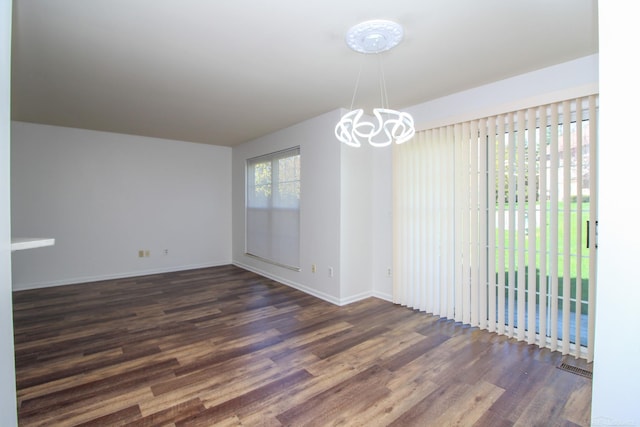 249 Brookwood Dr Unit 4, South Lyon, MI 48178 - empty room with dark wood-type flooring, a chandelier, and baseboards