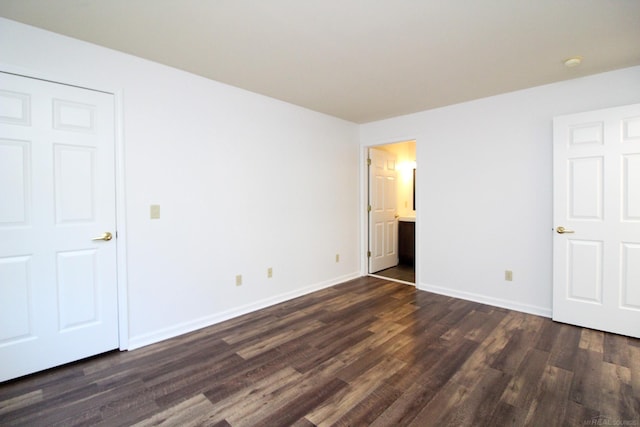 249 Brookwood Dr Unit 4, South Lyon, MI 48178 - unfurnished bedroom featuring dark wood finished floors, baseboards, and ensuite bath