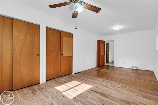 18467 Pershing St, Livonia, MI 48152 - unfurnished bedroom with two closets, light wood-type flooring, and ceiling fan