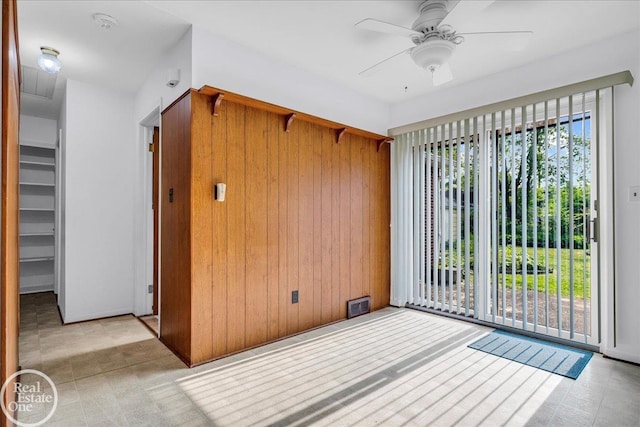 18467 Pershing St, Livonia, MI 48152 - spare room featuring ceiling fan, wood walls, and a smoke detector