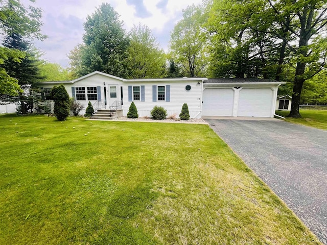2600 S Hill Rd, Gladstone, MI 49837 - manufactured / mobile home with a garage, asphalt driveway, and a front lawn