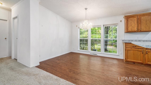 2600 S Hill Rd, Gladstone, MI 49837 - unfurnished dining area featuring ornamental molding, a chandelier, a textured ceiling, wood finished floors, and baseboards