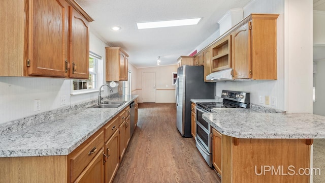 2600 S Hill Rd, Gladstone, MI 49837 - kitchen with appliances with stainless steel finishes, under cabinet range hood, a sink, light wood-type flooring, and crown molding