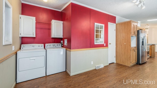 2600 S Hill Rd, Gladstone, MI 49837 - washroom with cabinet space, a textured ceiling, wood finished floors, washing machine and dryer, and crown molding