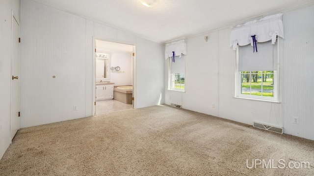 2600 S Hill Rd, Gladstone, MI 49837 - unfurnished bedroom with carpet flooring, multiple windows, connected bathroom, and a sink