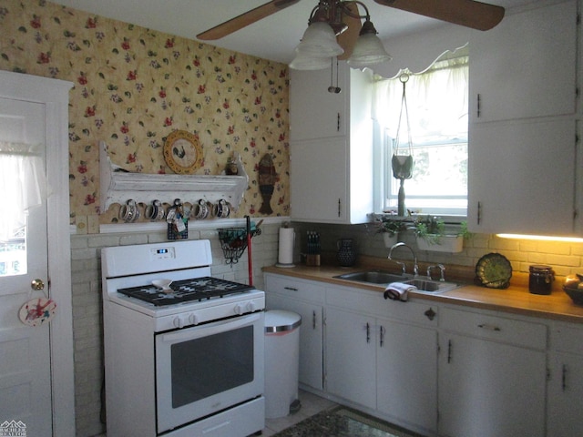 337 N 2nd St, Marine City, MI 48039 - kitchen with white gas range, ceiling fan, a sink, wallpapered walls, and light countertops