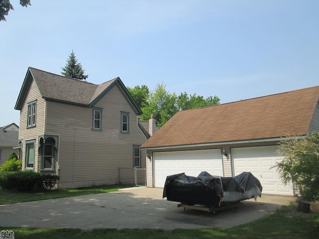 337 N 2nd St, Marine City, MI 48039 - view of side of home featuring a garage, an outdoor structure, roof with shingles, and concrete driveway