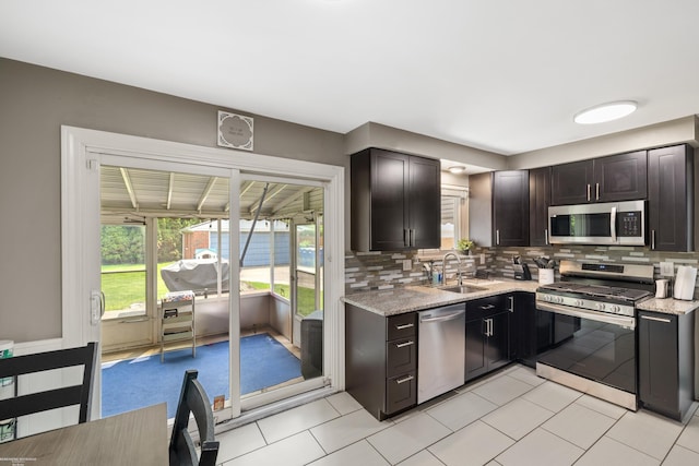 13040 Common Rd, Warren, MI 48088 - kitchen with appliances with stainless steel finishes, a sink, backsplash, light stone counters, and light tile patterned flooring