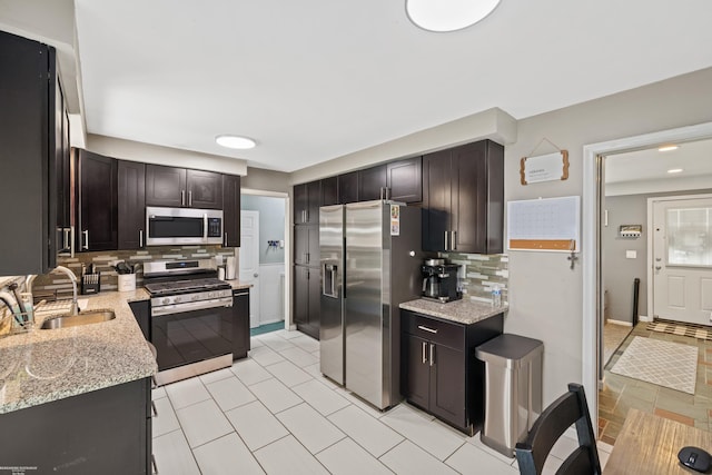 13040 Common Rd, Warren, MI 48088 - kitchen featuring appliances with stainless steel finishes, backsplash, a sink, light stone countertops, and dark brown cabinets