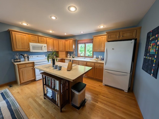 5663 Macintosh Dr, Bay City, MI 48706 - kitchen featuring white appliances, light countertops, light wood-type flooring, a center island, and recessed lighting