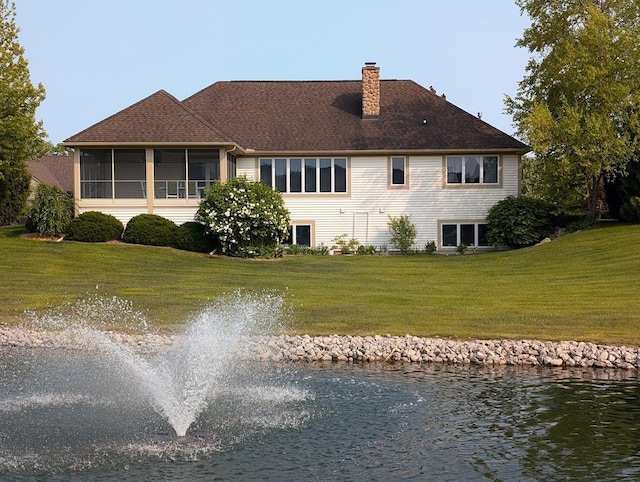 5663 Macintosh Dr, Bay City, MI 48706 - back of house featuring a chimney, a water view, a lawn, and a sunroom