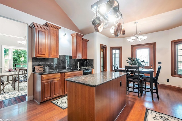 33473 Mulvey Rd, Fraser, MI 48026 - kitchen featuring a chandelier, black dishwasher, light wood-style flooring, brown cabinetry, and vaulted ceiling