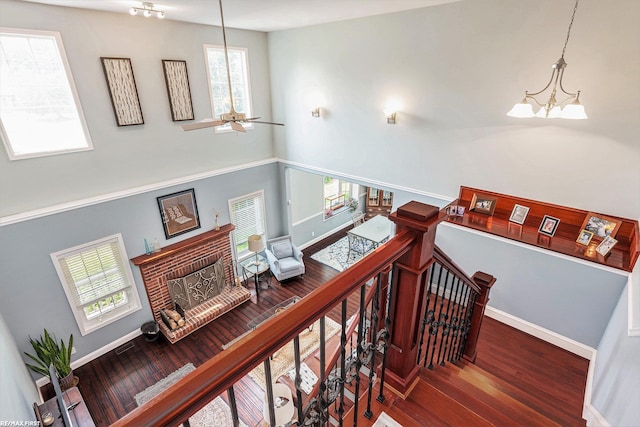 33473 Mulvey Rd, Fraser, MI 48026 - stairs featuring a chandelier, a fireplace, wood finished floors, baseboards, and a high ceiling