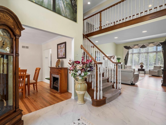 15158 Towering Oaks Dr, Shelby Twp, MI 48315 - stairway featuring ornamental molding, a fireplace, baseboards, a towering ceiling, and recessed lighting
