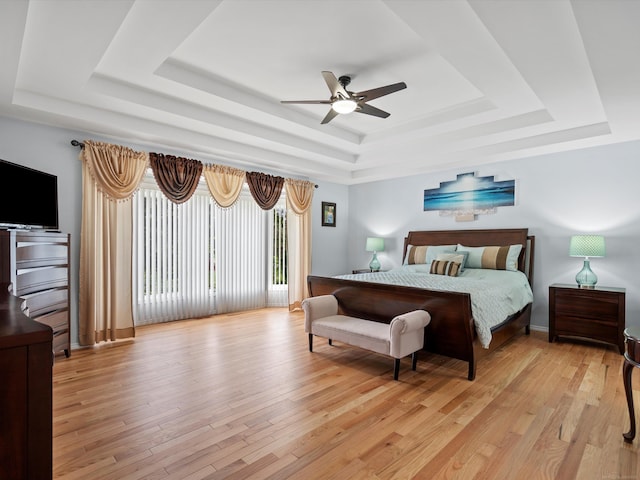 15158 Towering Oaks Dr, Shelby Twp, MI 48315 - bedroom featuring a tray ceiling, light wood-style flooring, a ceiling fan, and access to outside