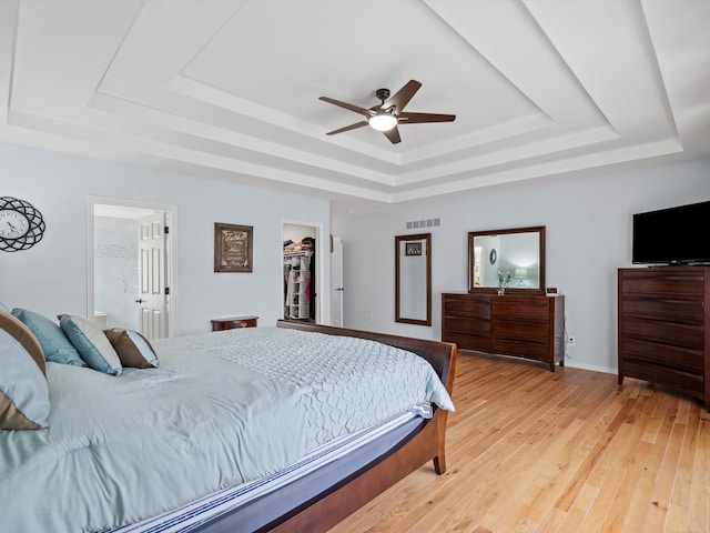 15158 Towering Oaks Dr, Shelby Twp, MI 48315 - bedroom featuring a tray ceiling, light wood finished floors, and ceiling fan