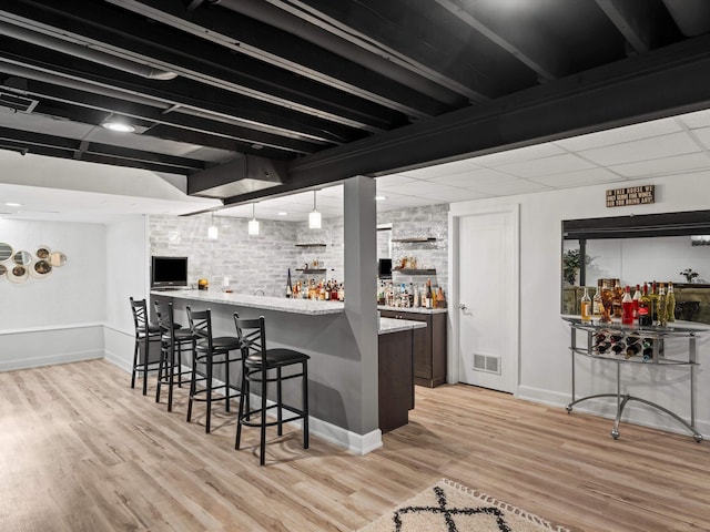 15158 Towering Oaks Dr, Shelby Twp, MI 48315 - indoor wet bar featuring light wood-type flooring, baseboards, and decorative light fixtures