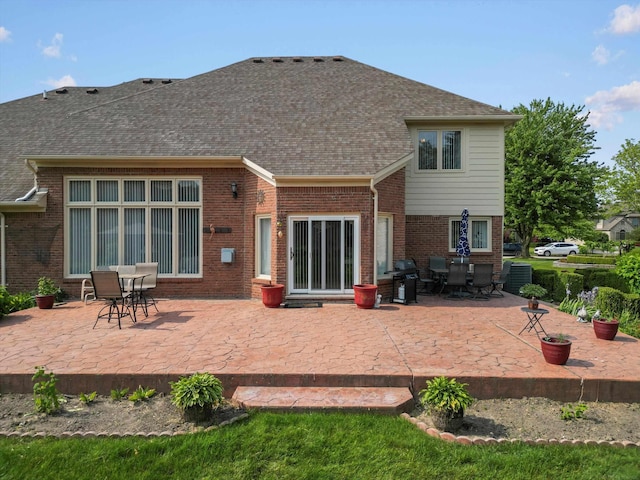 15158 Towering Oaks Dr, Shelby Twp, MI 48315 - back of house with a patio area, roof with shingles, brick siding, and outdoor dining space