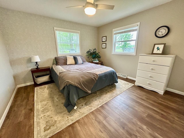 6586 N Coleman Rd, Coleman, MI 48618 - bedroom with multiple windows, wood finished floors, baseboards, and a ceiling fan