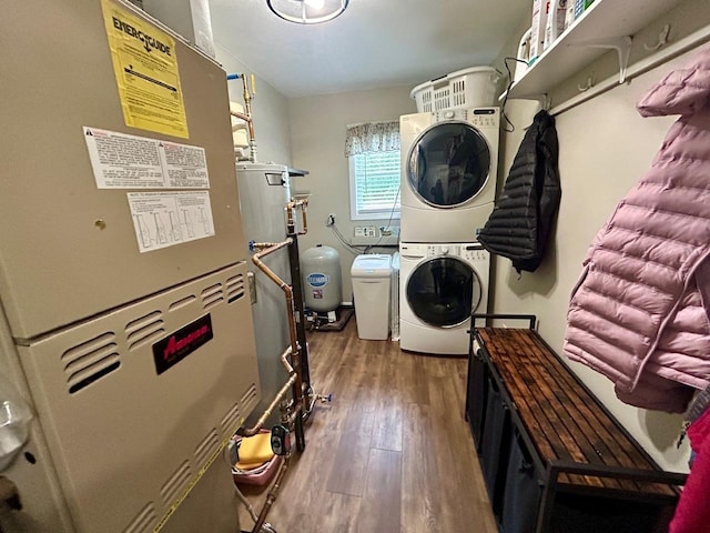 6586 N Coleman Rd, Coleman, MI 48618 - washroom with stacked washing machine and dryer, wood finished floors, and heating unit