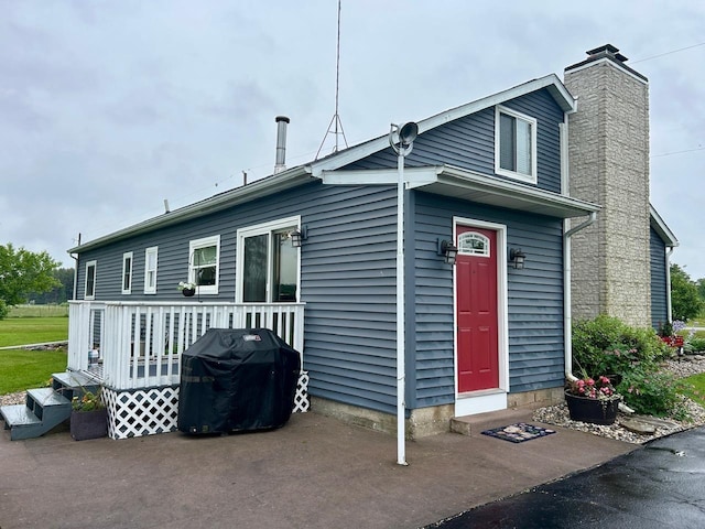 6586 N Coleman Rd, Coleman, MI 48618 - view of front of home featuring a chimney and a wooden deck