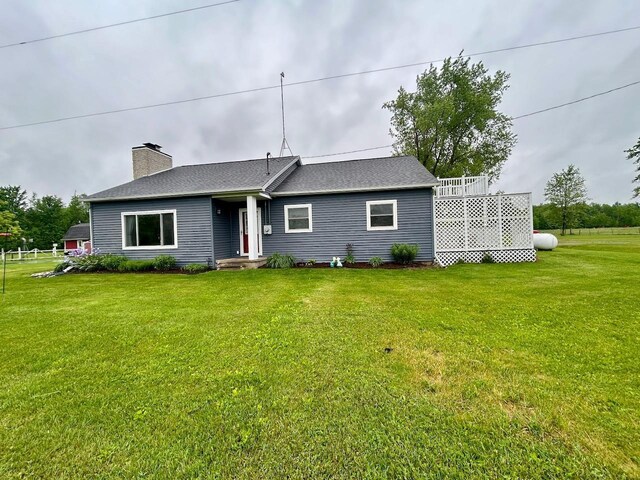 6586 N Coleman Rd, Coleman, MI 48618 - rear view of property featuring a lawn, a chimney, and a shingled roof