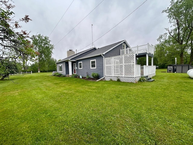 6586 N Coleman Rd, Coleman, MI 48618 - rear view of house featuring a yard, a chimney, and a wooden deck