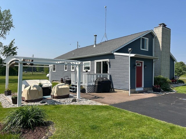 6586 N Coleman Rd, Coleman, MI 48618 - back of property with a wooden deck, a chimney, and a yard