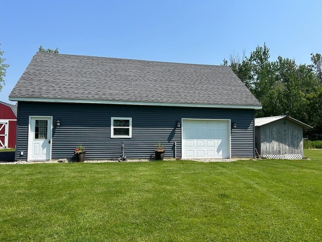 6586 N Coleman Rd, Coleman, MI 48618 - back of property with an outdoor structure, a lawn, roof with shingles, and a detached garage