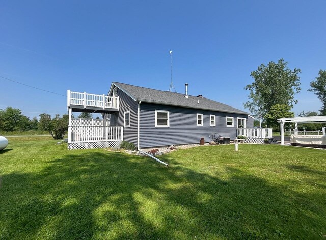 6586 N Coleman Rd, Coleman, MI 48618 - back of property featuring a deck, a yard, and a shingled roof