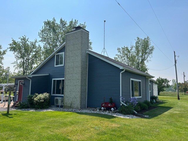 6586 N Coleman Rd, Coleman, MI 48618 - view of property exterior with a cooling unit, a yard, and a chimney
