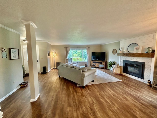 6586 N Coleman Rd, Coleman, MI 48618 - living room with wood finished floors, crown molding, a fireplace, baseboards, and a textured ceiling