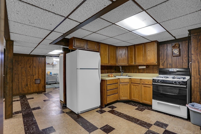 28052 Loretta Ave, Warren, MI 48092 - kitchen with freestanding refrigerator, range with gas stovetop, a sink, light countertops, and wooden walls