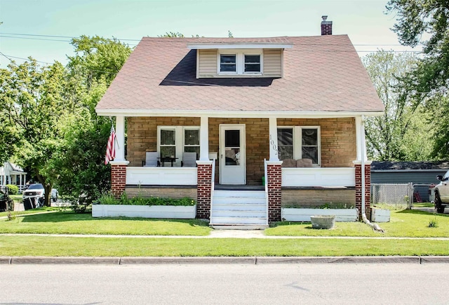 1002 Garfield St, Port Huron, MI 48060 - view of front of home featuring covered porch, a chimney, a front lawn, and stone siding