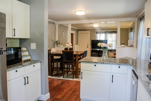 1002 Garfield St, Port Huron, MI 48060 - kitchen featuring black microwave, dark wood-style flooring, white cabinets, tasteful backsplash, and light stone counters