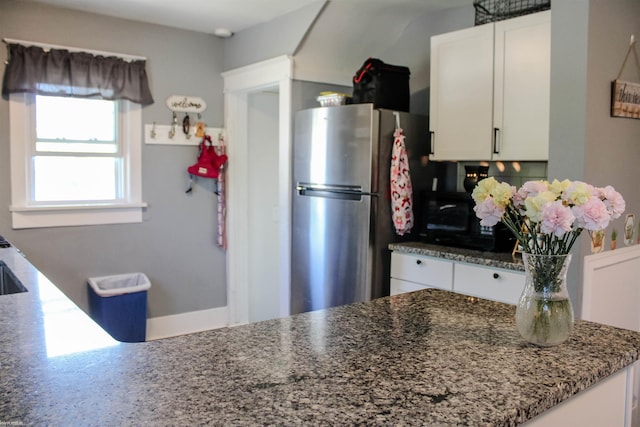1002 Garfield St, Port Huron, MI 48060 - kitchen featuring freestanding refrigerator, white cabinetry, and dark stone counters