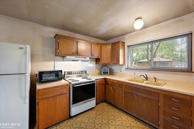 14108 La Chene Ave, Warren, MI 48088 - kitchen featuring white appliances, a sink, under cabinet range hood, light countertops, and brown cabinets