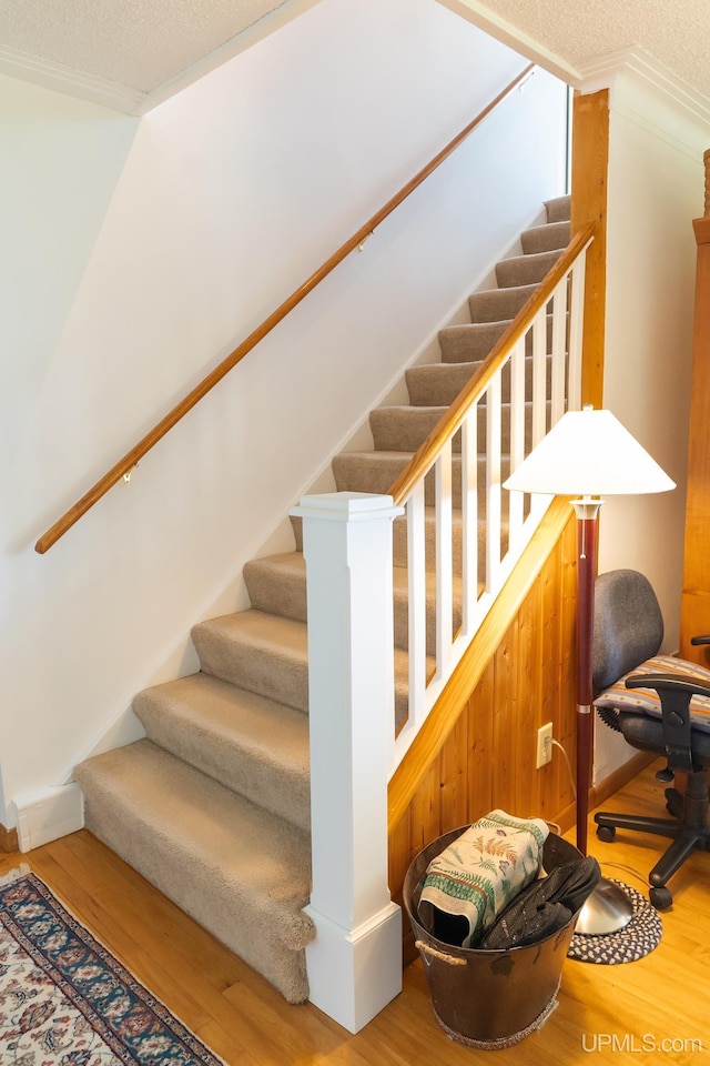 1426 Washington St, Munising, MI 49862 - stairs featuring wood finished floors, crown molding, and a textured ceiling
