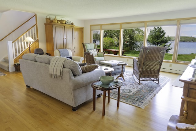 1426 Washington St, Munising, MI 49862 - living room featuring plenty of natural light, light wood-type flooring, baseboard heating, and stairway