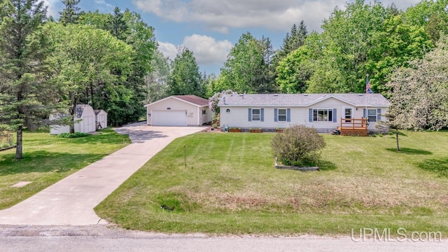 11745 T Rd, Rapid River, MI 49878 - view of front of house with an outbuilding, a detached garage, a wooden deck, a front yard, and view of wooded area