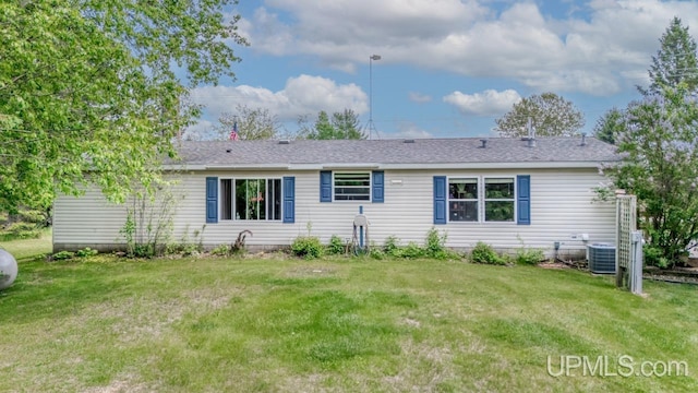 11745 T Rd, Rapid River, MI 49878 - view of front facade featuring central AC unit, a front yard, and a shingled roof
